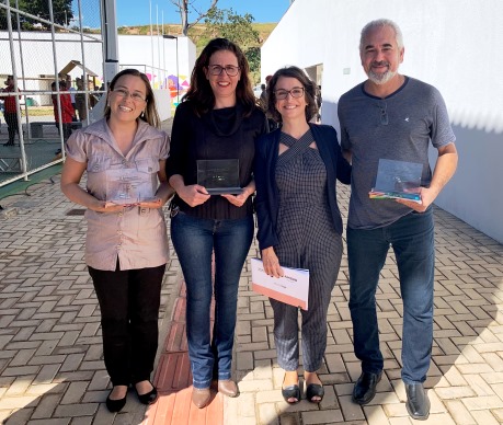 Os diretores das três escolas estaduais de Brumadinho - Shirley Cristina da Silva, da Escola Estadual Abelardo Duarte Passos, Elania Aparecida de Assis Amabis, da Escola Estadual Paulo Neto Alkimin, e Márcio Roberto Lopes de Sousa, da Escola Estadual Paulina Aluottto Ferreira - após receberem a homenagem, com a secretária Julia Sant'Anna. Foto: Franciele Xavier (SEE/MG)